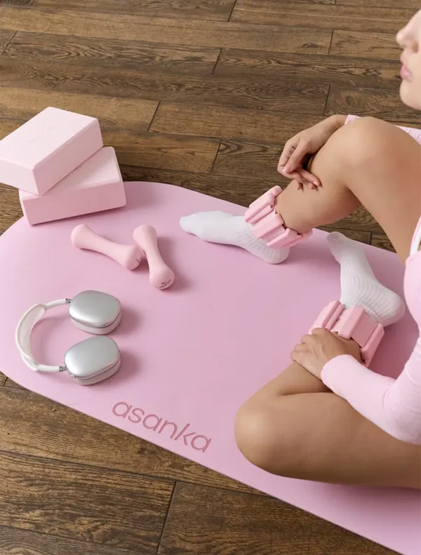 Tapete de yoga rosa com halteres, blocos e meias de treino